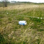 Aluminum can tied to wire fence.