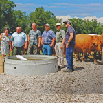 Project manager Neils Munk (third from left)
and farmer Finley Cameron (to Munk’s left) show off the new water system.