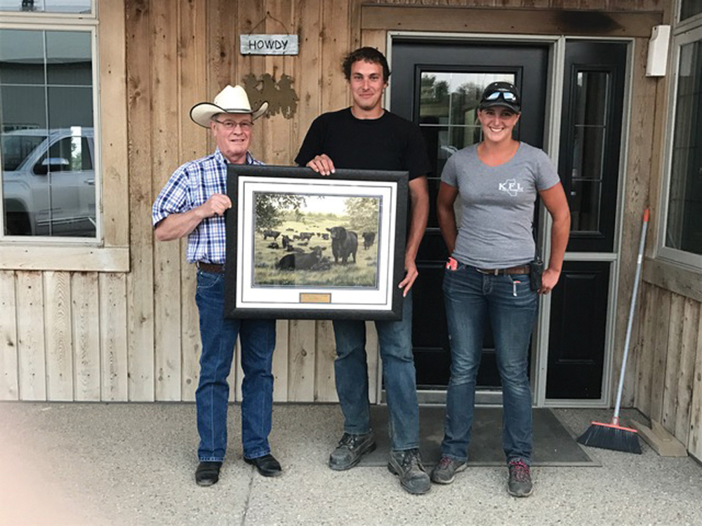 Brian Good (l) of the Canadian Angus Association presents the award to Jordan and Megan Kolk.