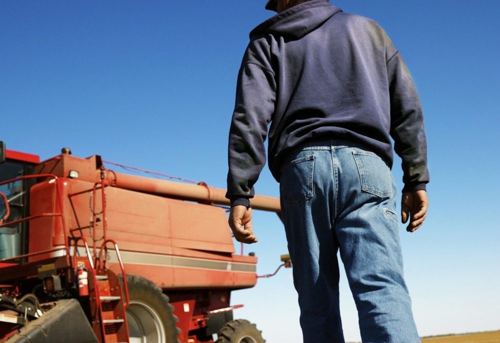 Farmer walking toward combine.