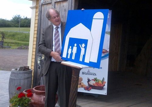 New Brunswick’s ag minister Michael Olscamp, shown here at Moncton in June last year launching new highway signage for agri-tourism sites, was among the provincial Tories defeated in Monday night’s election. (GNB.ca)
