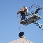 PAMI researchers install a probe in a canola bin as part of a temperature monitoring study, which ran from June through to mid-August 2016. (PAMI.ca)