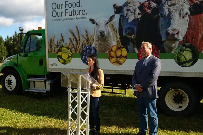 Newfoundland and Labrador’s minister of fisheries and land resources, Gerry Byrne, is shown here at right with Western Agriculture Centre research manager Sabrina Ellsworth and the department’s “Agri-Truck” promotional vehicle at Pynn’s Brook in September 2018. (Gov.nl.ca)
