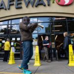 Reginald Conyers, a traveling busker, plays the trumpet outside a Safeway while people observing social distancing wait in line to enter the store in Oakland on March 20, 2020. (Photo: Reuters/Kate Munsch)