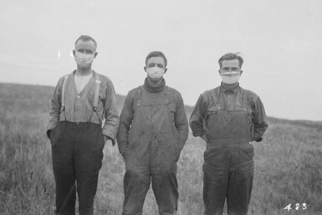 Three men in Alberta wearing face masks in 1918 during the Spanish influenza epidemic.