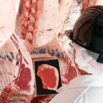 A beef-industry worker grades a carcass. Canada and the U.S. produce the highest-quality beef in the world and more than any other nation.