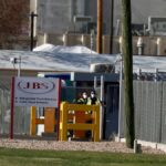 Security wear face masks at the Greeley, Colorado, JBS USA meat packing plant where two staff members had died of COVID-19, April 8, 2020. Photo: REUTERS/Jim Urquhart/File Photo