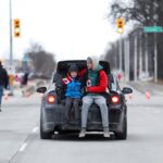 A man and a child ride away from a protest site at Windsor, Ont. on Feb. 12, 2022. (Photo: Reuters/Carlos Osorio)