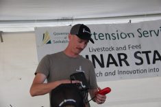 Katlin Lang, CEO of FarmSimple, shows attendees at the livestock tent at Ag in Motion his Herd Hand device.