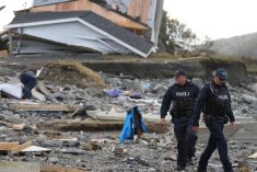 RCMP officers near a building destroyed by Hurricane Fiona at Port aux Basques, N.L. on Sept. 26, 2022. (Photo: Reuters/John Morris)
