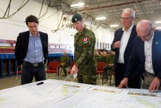 Prime Minister Justin Trudeau, federal Emergency Preparedness Minister Bill Blair and Edmonton MP and Tourism Minister Randy Boissonnault are briefed by Canadian Forces Lt. Col. Ben Schmidt at CFB Edmonton on May 15, 2023. (Photo: Reuters/Amber Bracken)