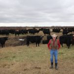 Don Campbell poses by the cow herd in April 2023.