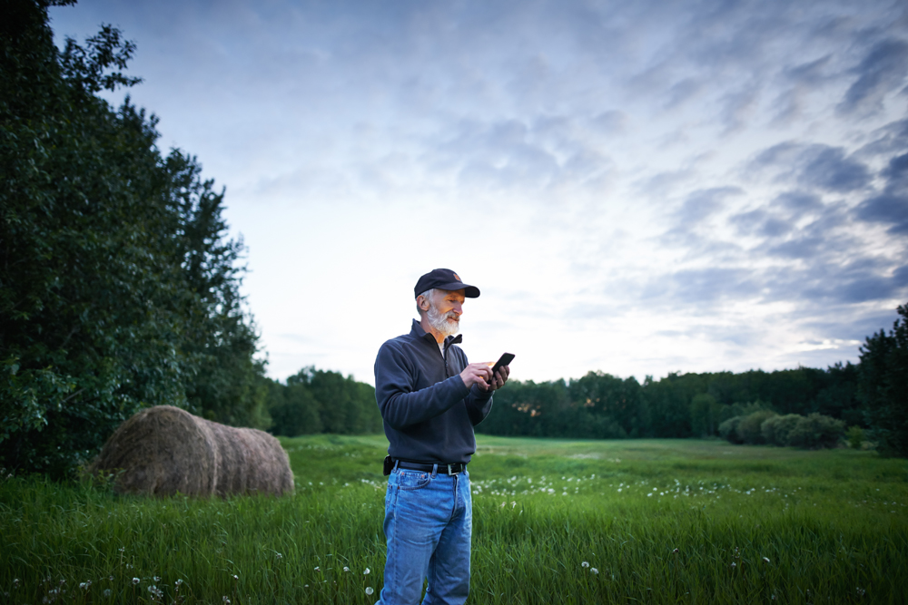 A farmer entering data on a cell phone. Think about how you record information while on the go when you’re considering new technology for the farm, says Betty-Jo Almond.