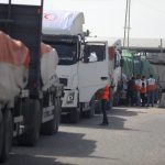 People gather around trucks carrying humanitarian aid that entered the Gaza Strip from Egypt via the Rafah border crossing on October 21, 2023. The first of 20 trucks carrying humanitarian aid entered the war-torn and besieged Gaza Strip on October 21 through the Rafah border crossing with Egypt, said AFP correspondents on both sides. Photo: Majdi Fathi/NurPhoto.