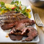a steak and salad on a white dinner plate