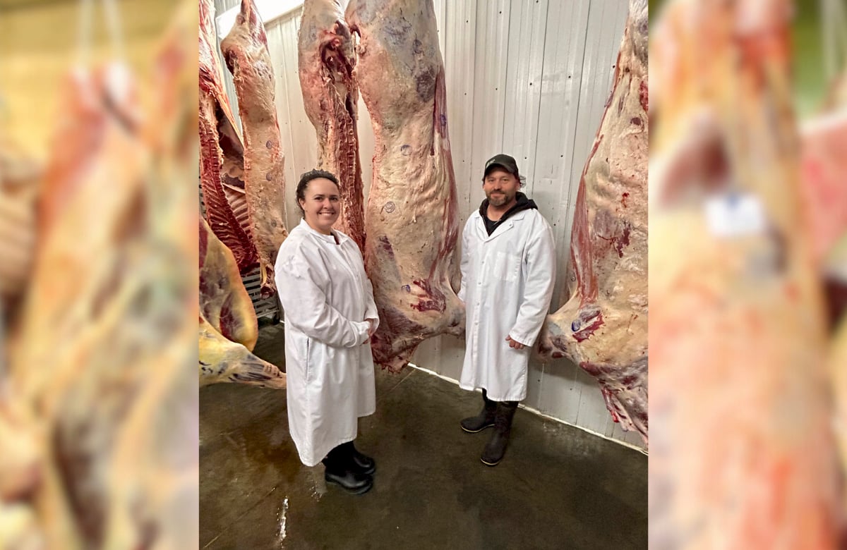 Sarah and Chad Hunt standing in an abbatoir with beef carcasses