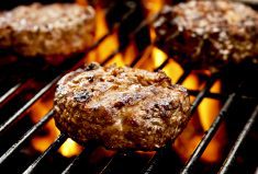 hamburgers cooking on a barbeque