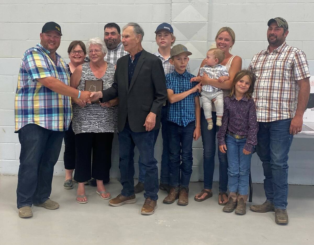 Canadian Gelbvieh Association vice-president Duncan Pearson presents the Elliot family with their plaque for their induction into the CGA Hall of Fame. Photo: Supplied