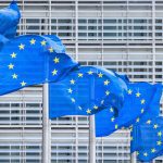 European Union Flags in a row in front of the facade of the European Commission Headquarter blowing in Brussels, Belgium. Photo: Getty Images Plus
