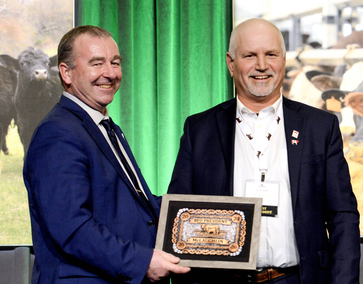 Jason Leblond, incoming Beef Farmers of Ontario president, left, presents Craig McLaughlin, out going president, with a mock-up of the belt buckle the organization had made to mark his nine-years on the board. Photo: Diana Martin